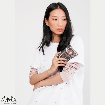 Mulher segura carteira preta com padrão