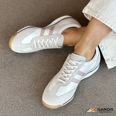 Ténis desportivos brancos e bege com riscas cor-de-rosa em uso