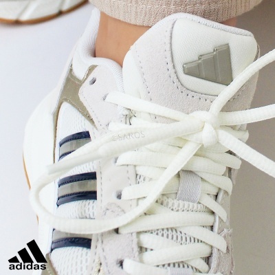 Tênis branco Adidas com detalhes cinza e azul escuro