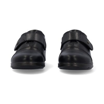 Sapatos pretos com tira de velcro sobre fundo branco