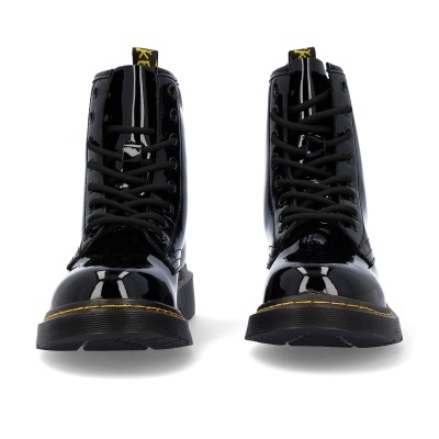 Botas pretas de verniz com solas pretas e costuras amarelas em fundo branco