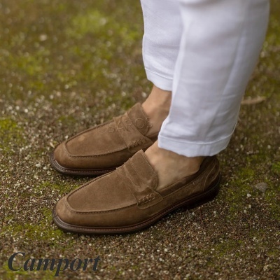 Sapatos castanhos em camurça estilo mocassim com sola castanha usados com calças brancas