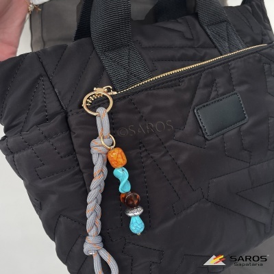 Mala acolchoada preta com zíper dourado e pendente colorido