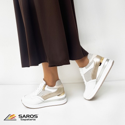 Ténis brancos com detalhes dourados e bege usados para estilo casual