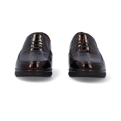 Sapatos mocassin de couro castanho com textura de pele de crocodilo sobre fundo branco