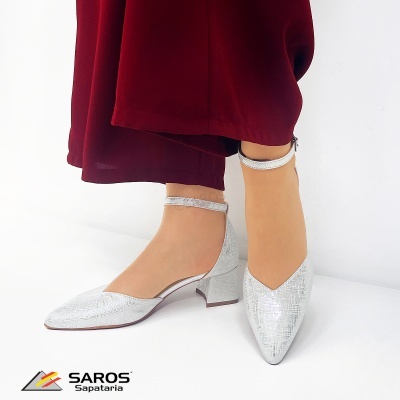 Sapatos prateados com salto médio e tira no tornozelo, calças vermelhas