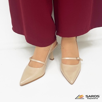 Sapatos de salto alto bege com tira e calças vermelhas sobre fundo branco