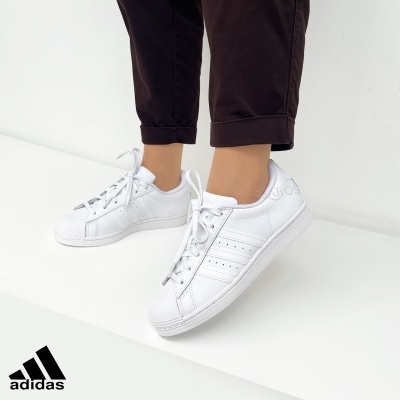 Ténis Adidas Superstar brancos em pele com riscas perfuradas e biqueira reforçada