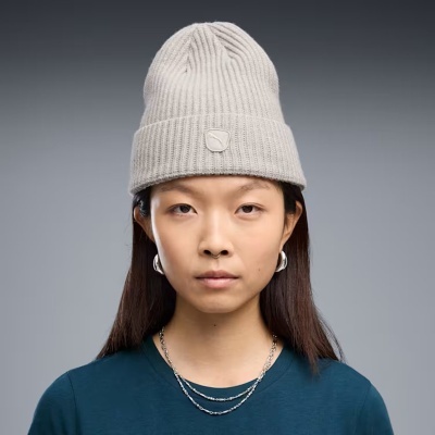 mulher a usar gorro cinzento claro de malha com padrão canelado e emblema
