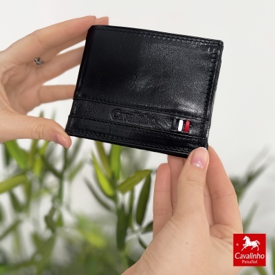 Carteira preta em pele com logo Cavalinho segurada por mãos
