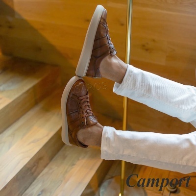 Sapatilhas de pele castanha com sola branca e atacadores, calças brancas, escadas de madeira