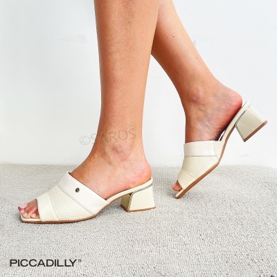 Mule creme com salto médio quadrado mostrado em pé feminino