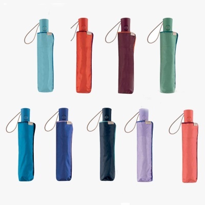 Dez guarda-chuvas compactos de várias cores com capas e alças de cordão, arrumados em duas filas sobre fundo branco