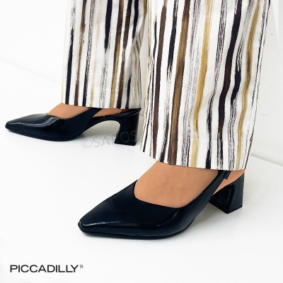 Sapatos de pele preta com salto quadrado e calças com riscas verticais