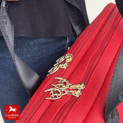 Mala vermelha com zíperes dourados com logótipo Cavalinho Penafiel.