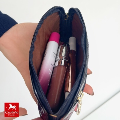 Bolsa pequena preta em pele com batons e lápis labial dentro