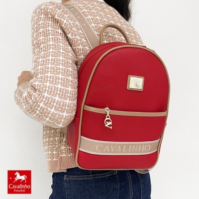 Mochila vermelha Cavalinho com detalhes castanhos usada por pessoa