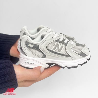 Ténis desportivo New Balance cinza e branco para criança com detalhes de malha e pele sintética