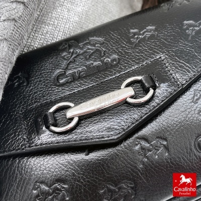 Mala preta de pele com padrão de cavalos em relevo e ferragem prateada com logo Cavalinho