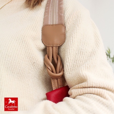 Alça de mala castanha em tecido e couro sobre suéter bege