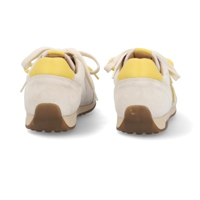 Ténis bege com detalhes amarelos vistos de trás