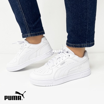 Ténis brancos PUMA em pele sintética com sola branca e atacadores.