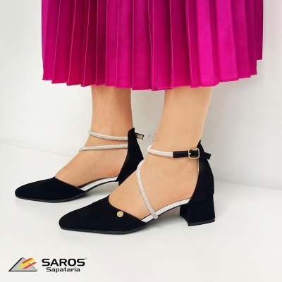 Sapatos pretos com tiras prateadas e saia rosa plissada
