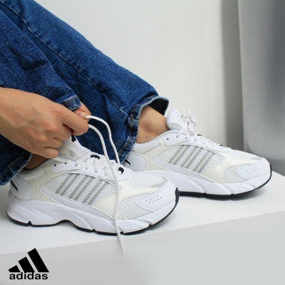 Ténis Adidas brancos com detalhes cinzentos em tecido e sintético.