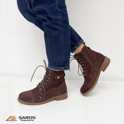 Botas castanhas em camurça com atacadores e fecho lateral usadas com calças de ganga