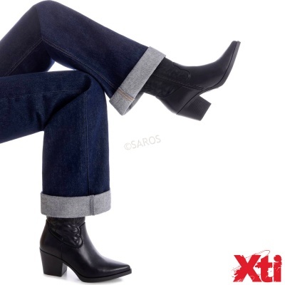 Botas pretas de salto médio em pele com calças de ganga azul