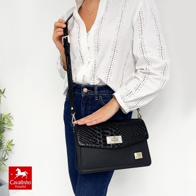 Mala preta de senhora tipo tiracolo com textura de pele de crocodilo e fecho metálico
