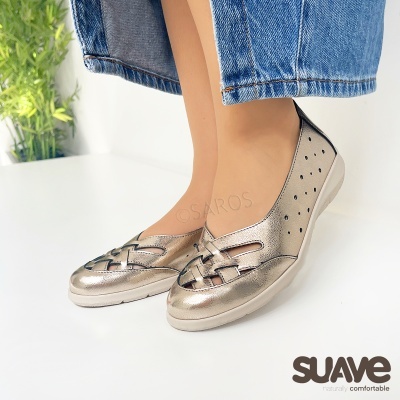 Sapatos dourados baixos femininos com padrão entrelaçado e detalhes perfurados usados com calça jeans azul