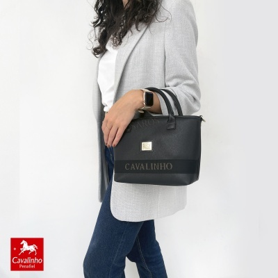 Mulher com saco de mão preto Cavalinho e roupa casual