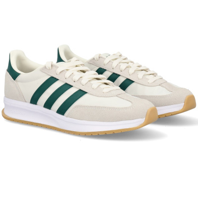 Sapatilhas desportivas bege claro com riscas verdes e sola bege.