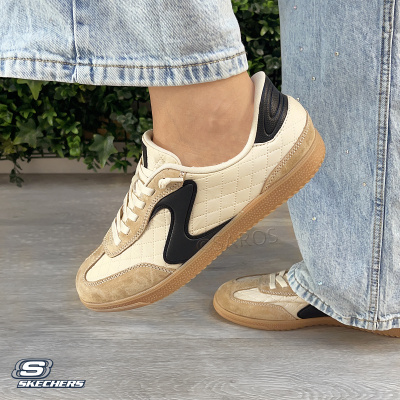 Tênis Skechers bege com detalhes pretos e sola castanha usados com calças de ganga azul claro