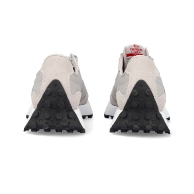 Sapatilhas cinzentas e brancas vistas de trás com sola preta e etiqueta vermelha na língua