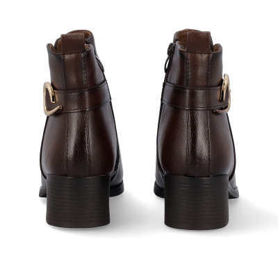 Botins castanhos escuros em pele com fivelas douradas e salto quadrado vistos de trás