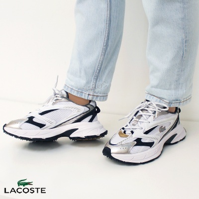 Ténis Lacoste brancos com detalhes prateados, pretos e dourados usados com jeans claros