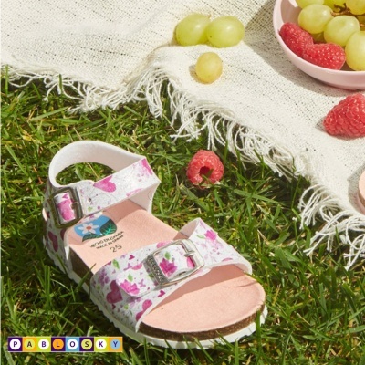 Sandália infantil estampada e frutas em relva com pano branco