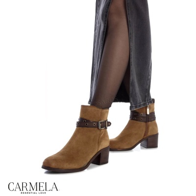 Botas castanhas claras em camurça com salto grosso e correia, usadas com calças pretas