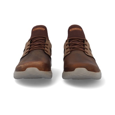 Par de sapatos desportivos castanhos Skechers sobre fundo branco