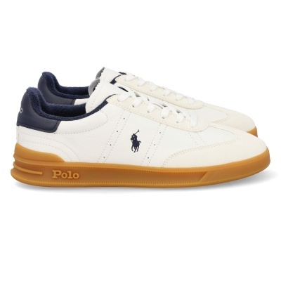 Ténis brancos com sola castanha, interior azul escuro e logo Polo em azul.