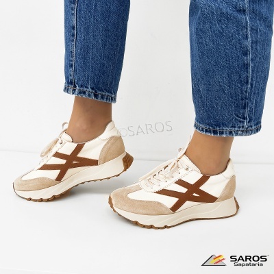 Ténis brancos e castanhos usados com calças de ganga