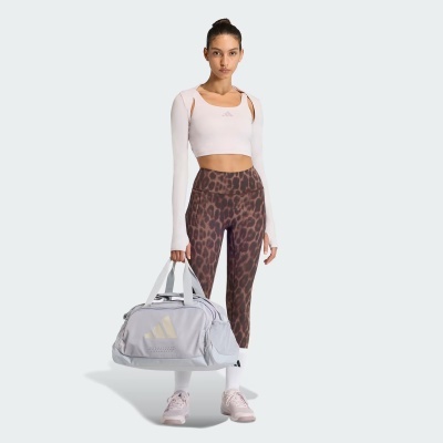 Modelo com roupa desportiva e mala de desporto com logótipo Adidas