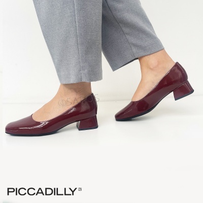 Sapatos vermelhos envernizados com salto baixo quadrado em fundo branco.