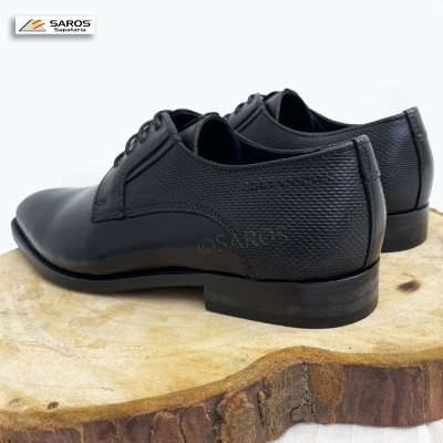 Sapatos masculinos pretos em couro com textura granulada e atacadores