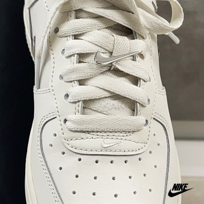 Tênis branco Nike com atacadores e fecho metálico prateado em forma de logotipo