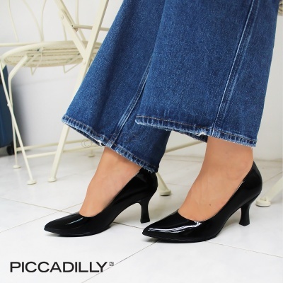 Sapatos de salto médio em verniz preto brilhante com calças de ganga azul
