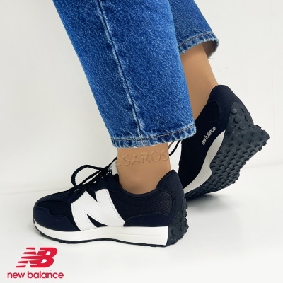 Ténis New Balance preto e branco usados com calças de ganga azul