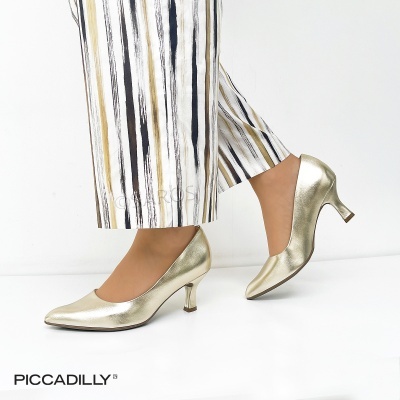 Sapatos dourados de salto baixo com calças brancas de riscas verticais